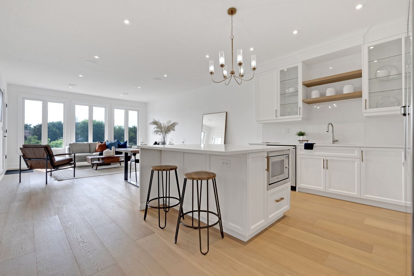 Open-concept kitchen and living area with wide-plank oak floors
